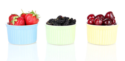 Ripe mulberries with cherry and strawberries in bowls isolated