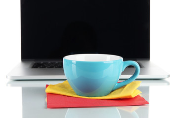 Blue cup on napkin on laptop background isolated on white