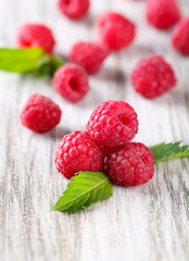 Ripe sweet raspberries on wooden background