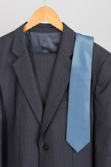 Suit and tie on hanger on white background