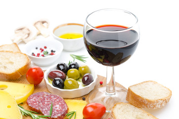 glass of red wine and appetizers - cheese, bread, salami, olives