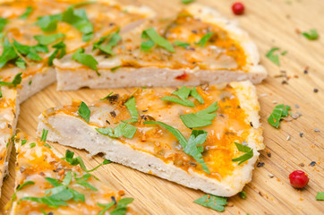 chicken pizza with tomato sauce, cheese and parsley on a wood