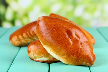 Fresh baked pasties, on wooden table, on bright background