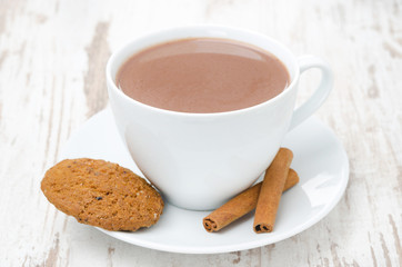 cup of cocoa with cinnamon and oatmeal cookies