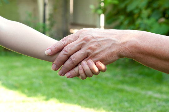 hands of young child and old senior outside