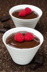 two bowls of chocolate mousse and fresh raspberries