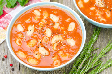 two bowls of tomato soup with pasta, white beans and rosemary