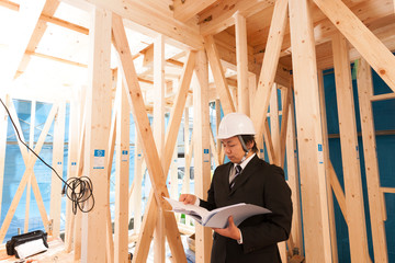 木造住宅の工事現場を確認する現場監督