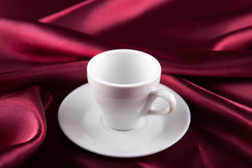 empty cup on a red silk