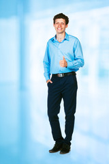 Happy young businessman standing with thumb up