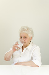 Seniorin über 80 trinkt Wasser