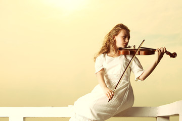 The blonde girl with a violin outdoor