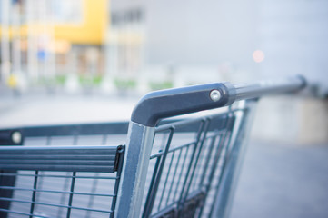 Empty grey shopping cart at supermarket entrance