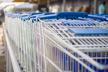 Rows of blue shopping carts on entrance of supermarket