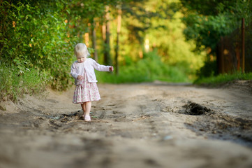 Little girl having a walk in the woods