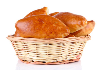 Fresh baked pasties in wicker basket, isolated on white