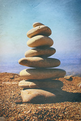 Pyramid of stones on beautiful beach as retro photography