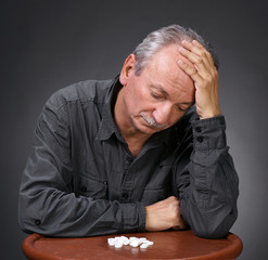 Senior man looking at pills