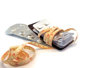 tablets and measuring tape, symbol photo for appetite suppressan