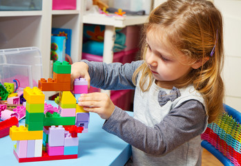 bambina che gioca con le costruzioni