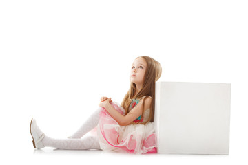 Fototapeta premium Dreamy little girl posing with cube in studio