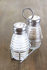 Salt and pepper mills, on wooden background