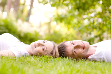young couple lying head to head on the grass