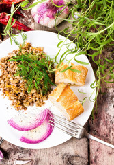 Buckwheat, bresd and herbs in white dish on  old dark wood backg