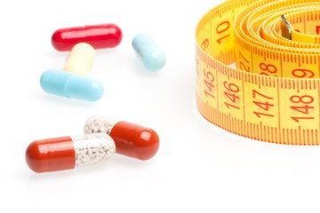 measuring tape and pills for dieting