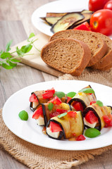 Eggplant rolls stuffed with cheese with a slice of tomato