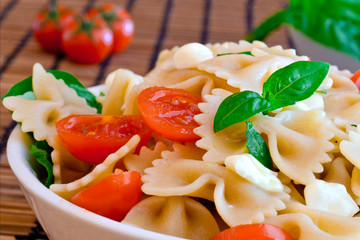 pasta with basil, tomatoes and italian cheese called mozzarella