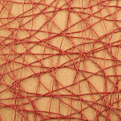 Cork mat covered with red thread