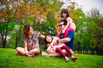 Family lying outdoors being playful and smiling