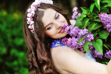 Beautiful girl and blossoming lilac trees