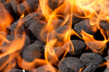 Kohle auf dem Grill samt loderndes Feuer