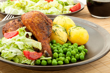 Roasted chicken legs with young potatoes
