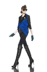 young fashion model in sunglasses with gloves walking in studio