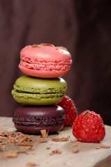 Colorful macaroons stacked on wooden plate