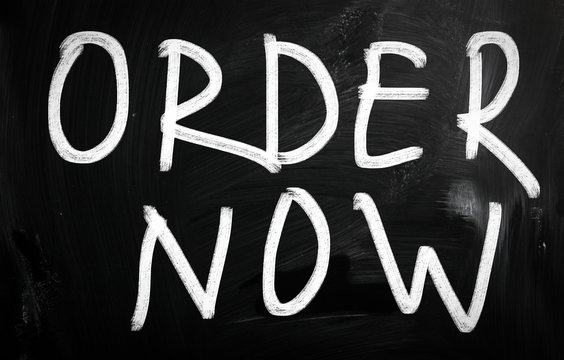 "Order now" handwritten with white chalk on a blackboard
