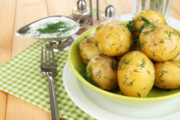 Boiled potatoes on platens on on napkins on wooden table