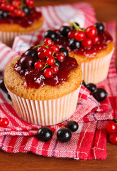 Tasty muffins with berries on wooden table