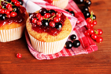 Tasty muffins with berries on wooden table