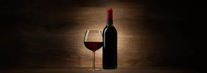 Photo sur Aluminium Vin bouteille verte avec du vin rouge et du verre sur un panorama en bois