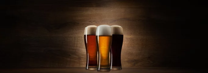 Wall murals Beer tree glass beer on wood background with copyspace