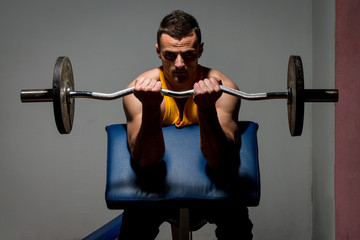 Fototapeta na wymiar fitness trainer doing heavy weight exercise for biceps