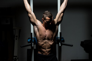 Fototapeta na wymiar handsome man exercising his abs at the gym