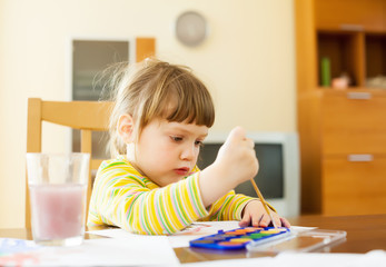 quiet two year child painting  with watercolor