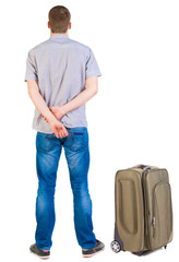 Back view of traveling man with suitcase looking up.
