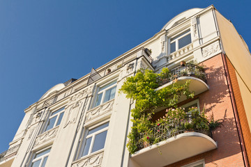 Altbau mit Stuck-Verzierung und bepflanzten Balkonen