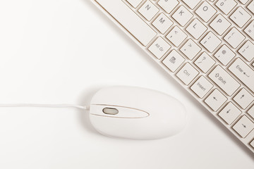 Close up of white wireless keyboard  and wired mouse